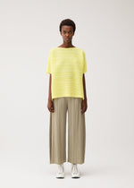 A model wears the PLEATS PLEASE ISSEY MIYAKE PAPER BOUNCE KNIT paper-bounce-knit-shirt-white.