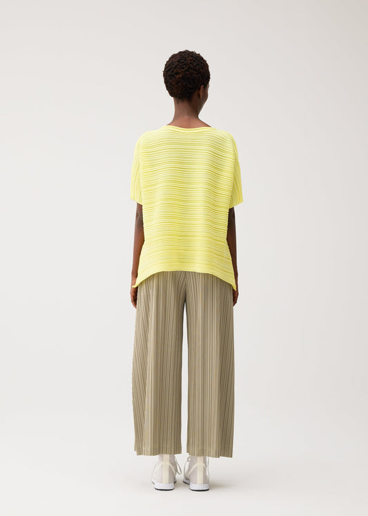 A model wears the PLEATS PLEASE ISSEY MIYAKE PAPER BOUNCE KNIT paper-bounce-knit-shirt-white.