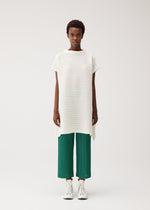 A model wears the PLEATS PLEASE ISSEY MIYAKE PAPER BOUNCE KNIT paper-bounce-knit-shirt-white-2.