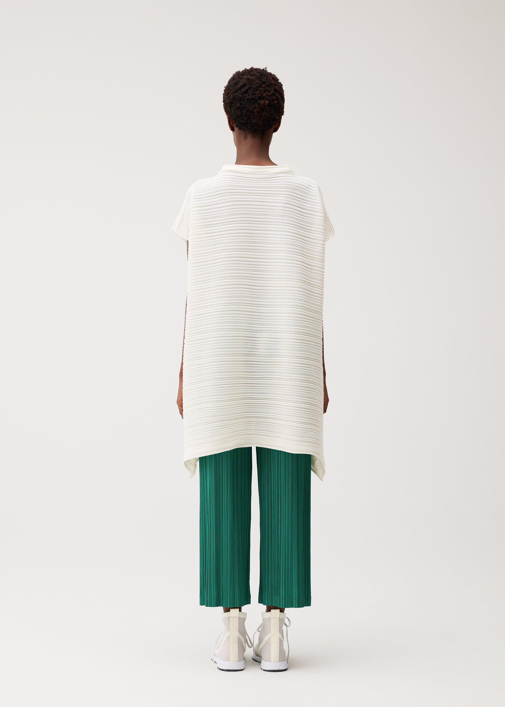 A model wears the PLEATS PLEASE ISSEY MIYAKE PAPER BOUNCE KNIT paper-bounce-knit-shirt-white-2.