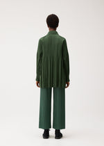 A model wears the PLEATS PLEASE ISSEY MIYAKE SMOOTH COAT coat.