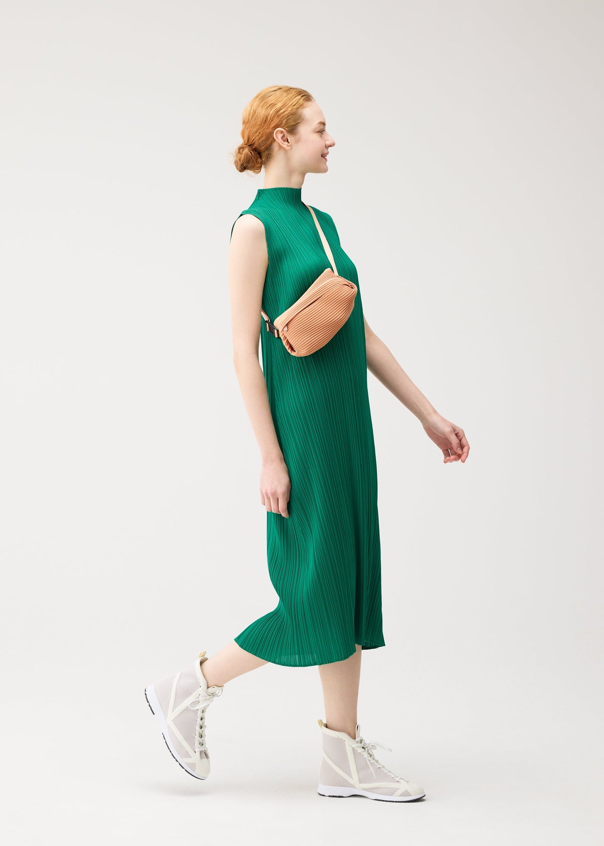 A model wears the PLEATS PLEASE ISSEY MIYAKE BIAS PLEATS WAIST BAG bias-pleats-waistbag-bag-fresh-green-2.