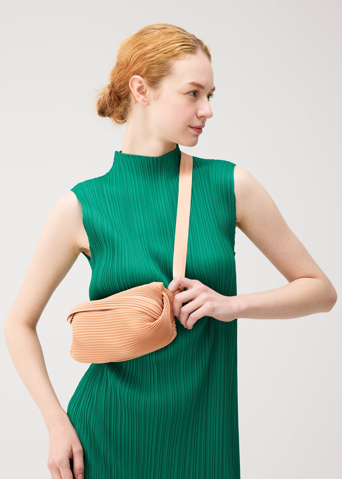A model wears the PLEATS PLEASE ISSEY MIYAKE BIAS PLEATS WAIST BAG bias-pleats-waistbag-bag-black-fw26.