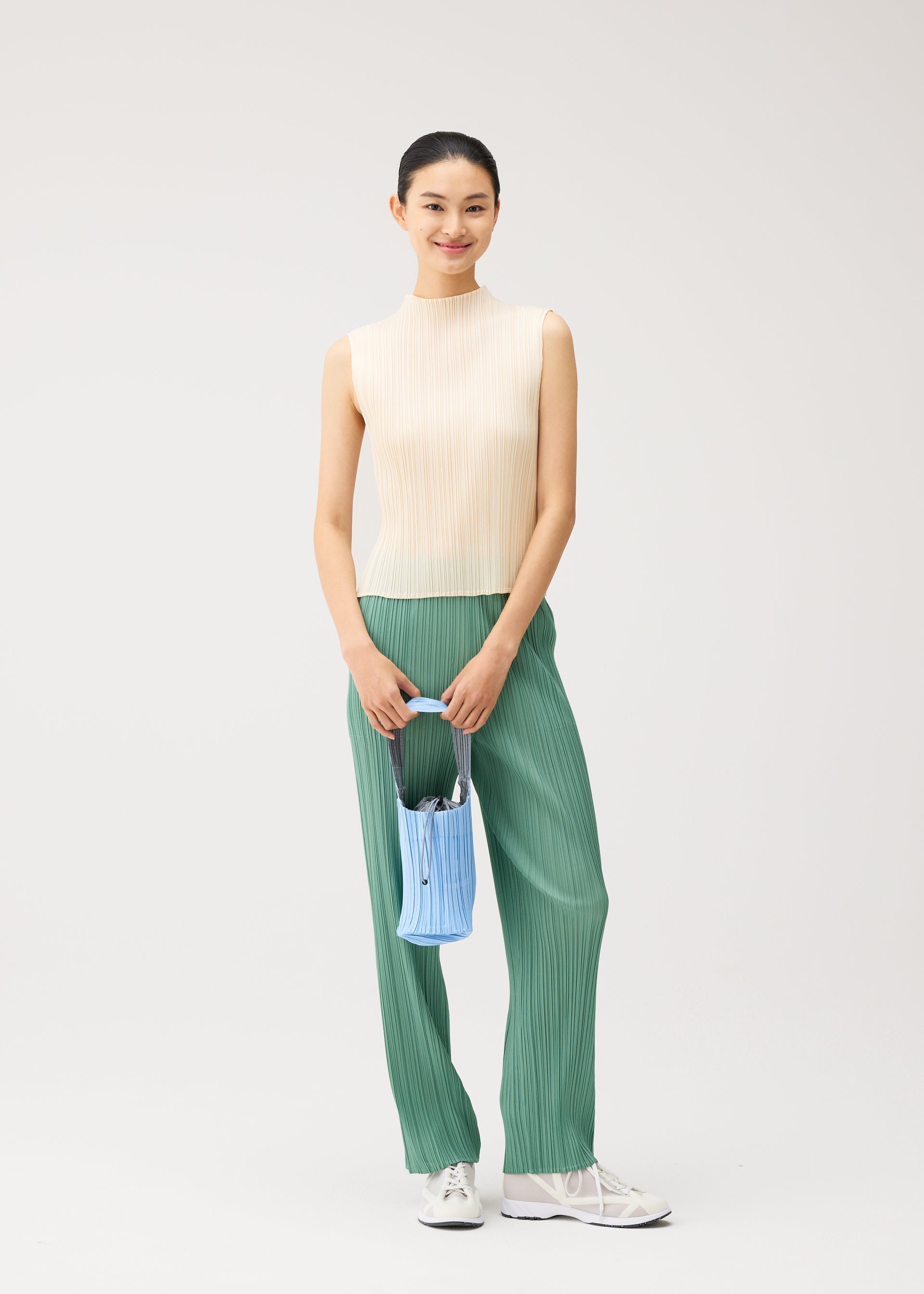 A model wears the PLEATS PLEASE ISSEY MIYAKE PLEATS SWAN BAG pleats-swan-bag-bag-black.