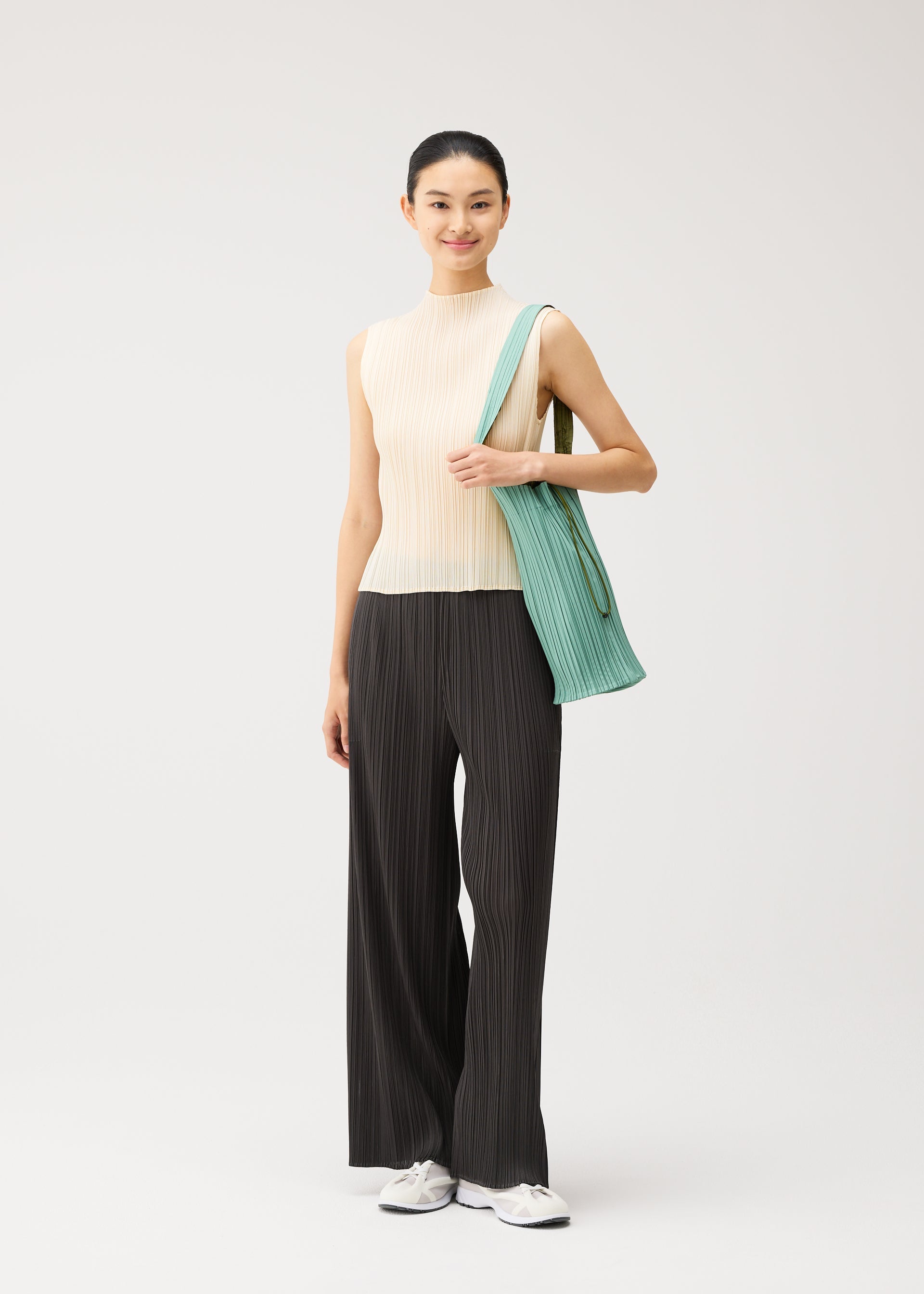 A model wears the PLEATS PLEASE ISSEY MIYAKE PLEATS SWAN BAG pleats-swan-bag-bag-black-1.