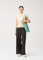 A model wears the PLEATS PLEASE ISSEY MIYAKE PLEATS SWAN BAG pleats-swan-bag-bag-light-blue-1.