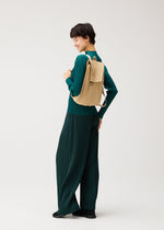 A model wears the PLEATS PLEASE ISSEY MIYAKE PLEATS KNAPSACK bag.